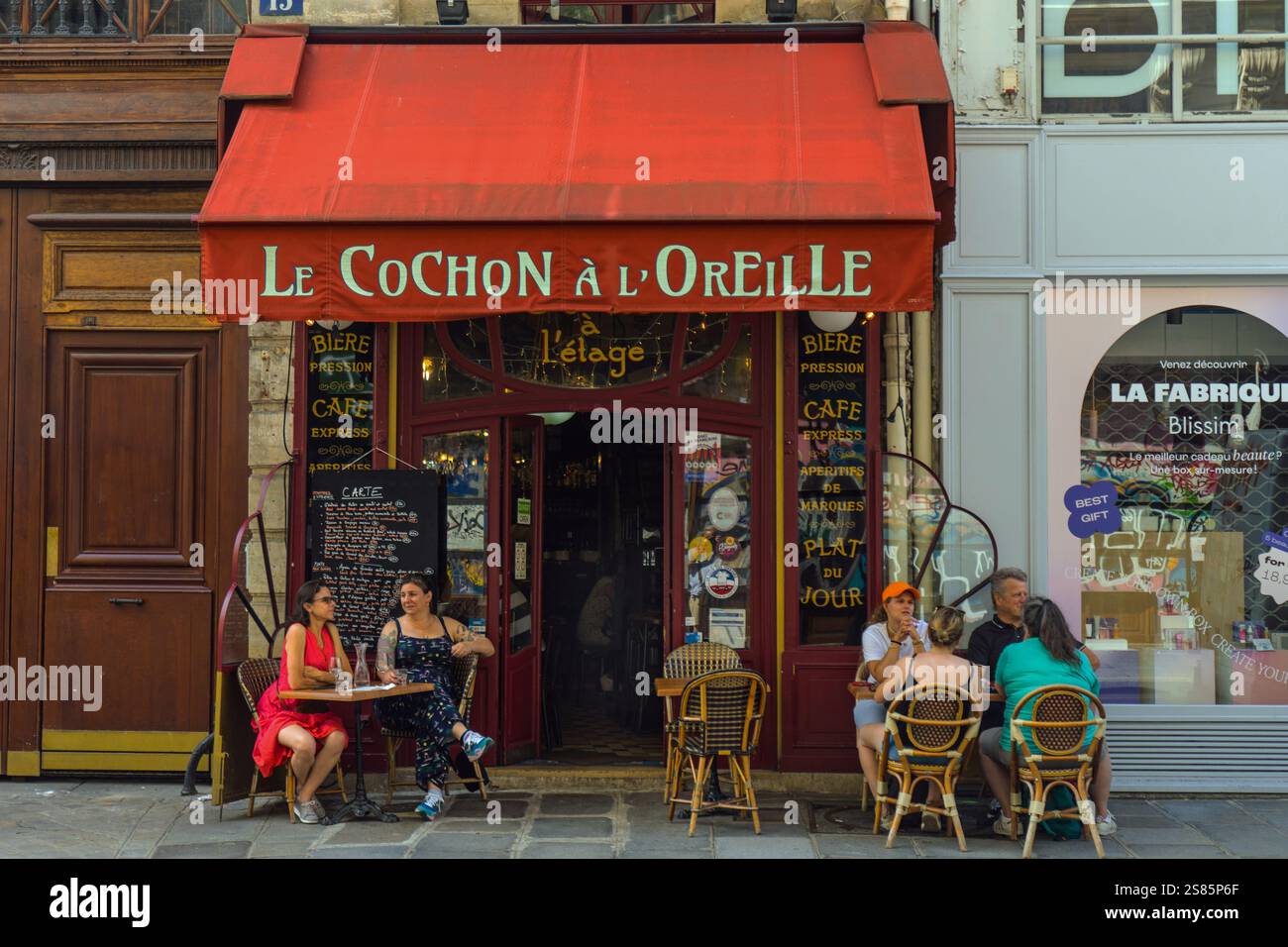 Les gens déjeunent devant le restaurant le Cochon à l'oreille, rue Montmartre, Paris, France Banque D'Images
