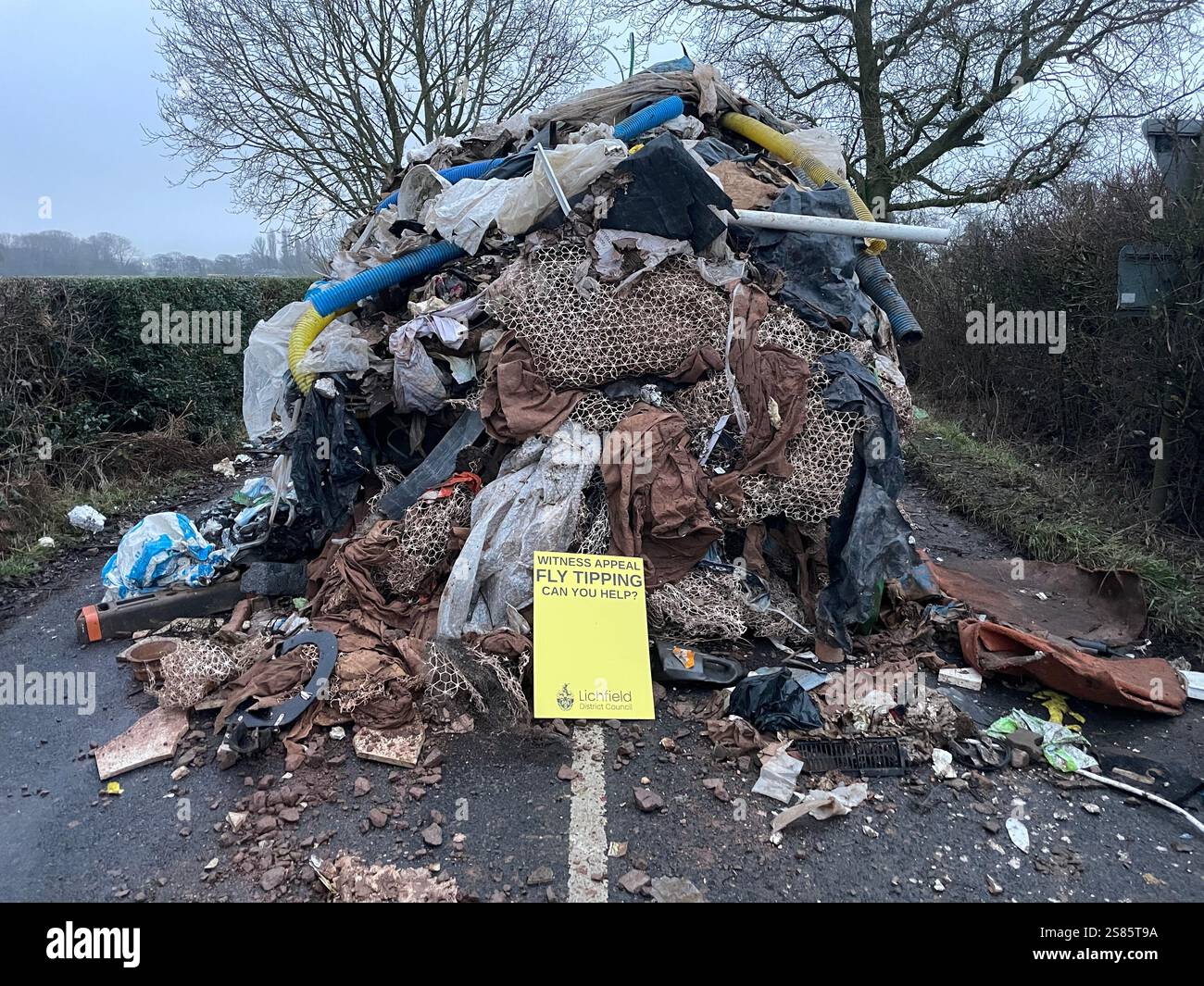 Le tas de déchets de 1 m de haut de Watery Lane, à la périphérie de Lichfield dans le Staffordshire. Les autorités locales recherchent des preuves vidéo pour retrouver les mouches qui ont déversé un énorme monticule de déchets de construction s'étendant sur plus de 40 pieds le long d'une route à deux voies, bloquant l'accès aux maisons et aux entreprises. Date de la photo : mardi 21 janvier 2025. Banque D'Images