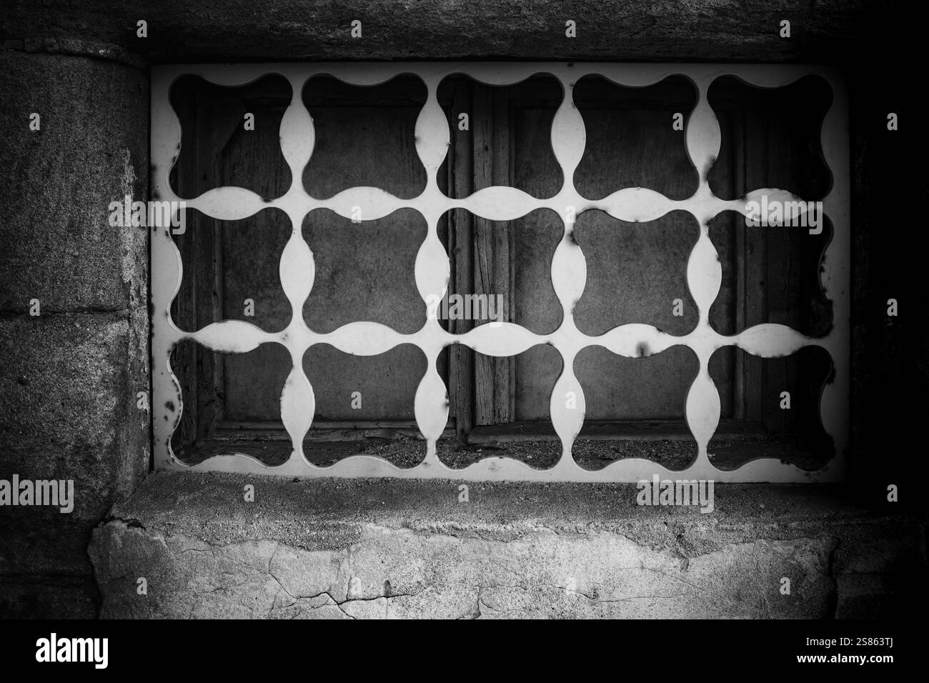 Design complexe de mur avec une fenêtre à motifs dans un bâtiment historique pendant la lumière du jour Banque D'Images