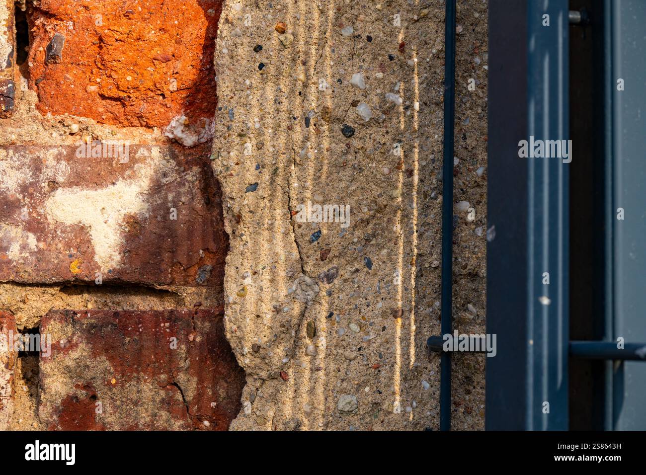 Mur texturé avec des éléments de brique et de béton présentant des motifs uniques de lumière et d'ombre Banque D'Images