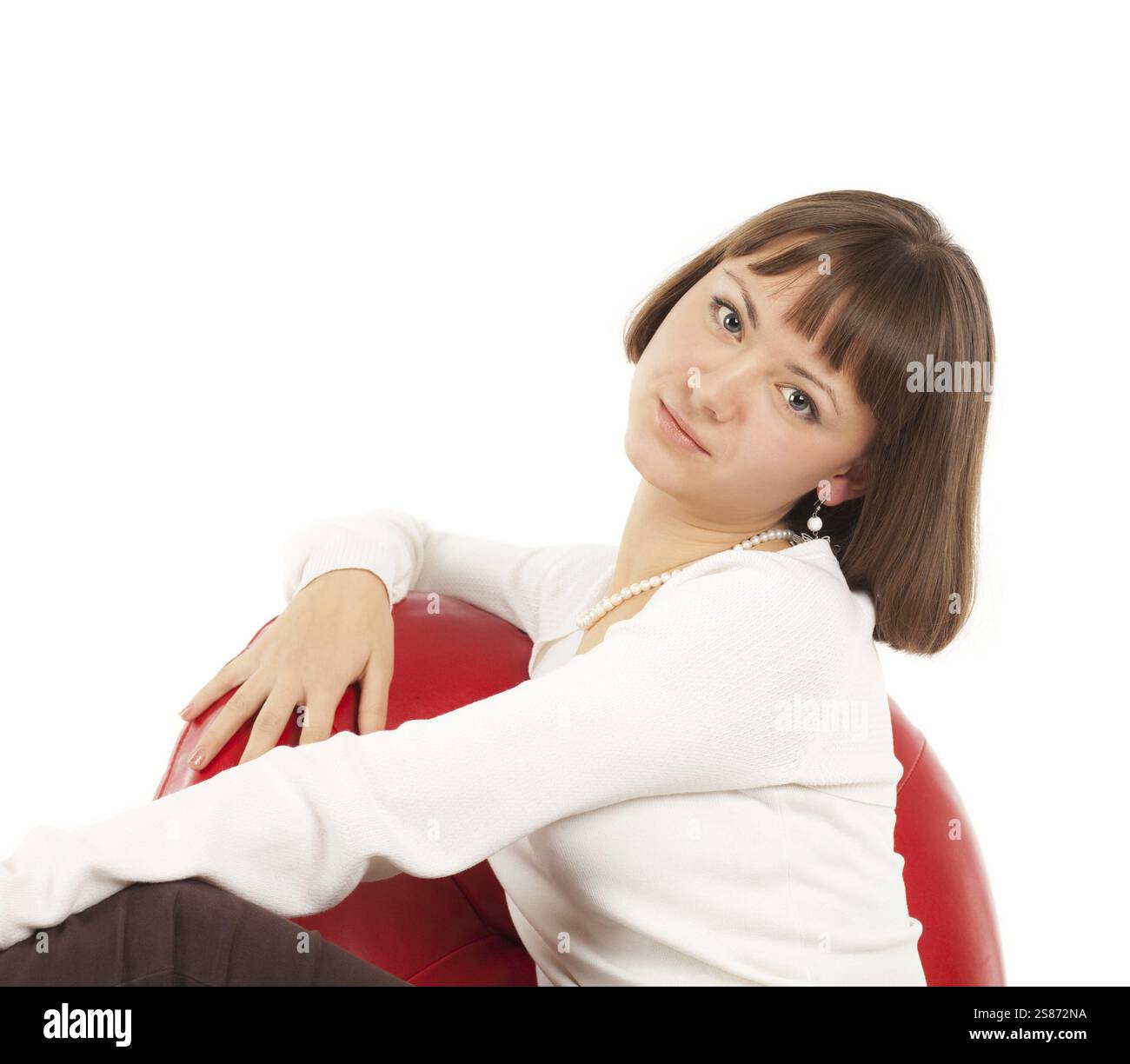 Jolie jeune femme blonde assise dans une chaise en cuir rouge, Fédération de Russie Banque D'Images