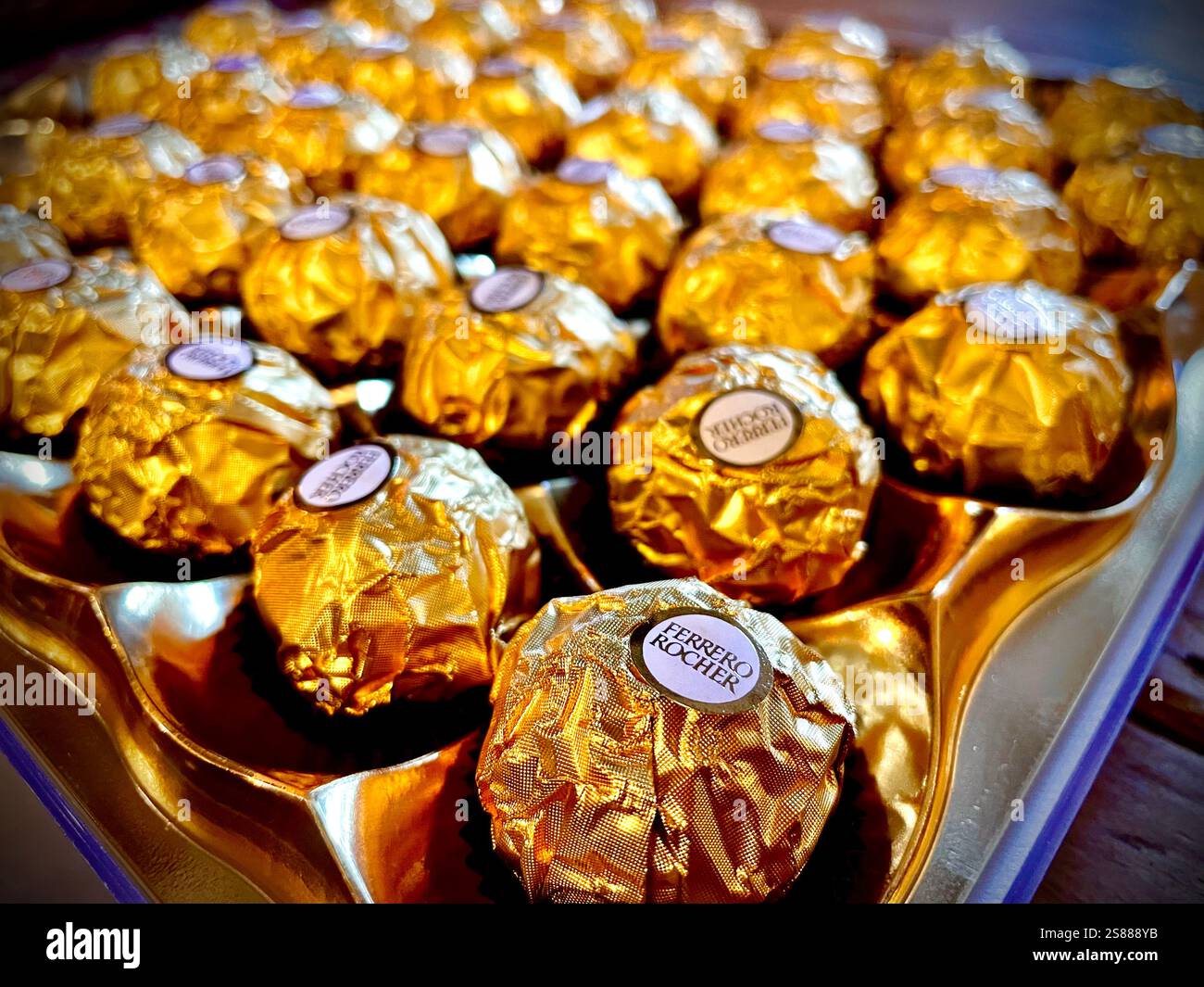 Ferrero Rocher Chocolates Noël 2024 Wiki : Ferrero Rocher ;est une marque de confiserie au chocolat et aux noisettes fabriquée par la société italienne Ferrero. Michele Ferrero est crédité en tant que créateur du produit. Chaque boule Ferrero Rocher est recouverte de papier d'aluminium et placée dans un papier dorsal. La confiserie est fabriquée à la machine et une grande partie de son processus de production est gardée secrète. Il est vendu dans le monde entier et est particulièrement associé à Noël. La marque est connue au Royaume-Uni, et dans d'autres pays comme le Mexique, par la populaire publicité des années 1990 'ambassadeurs' Ferrero Rocher : 'The Ambassador's Pa Banque D'Images