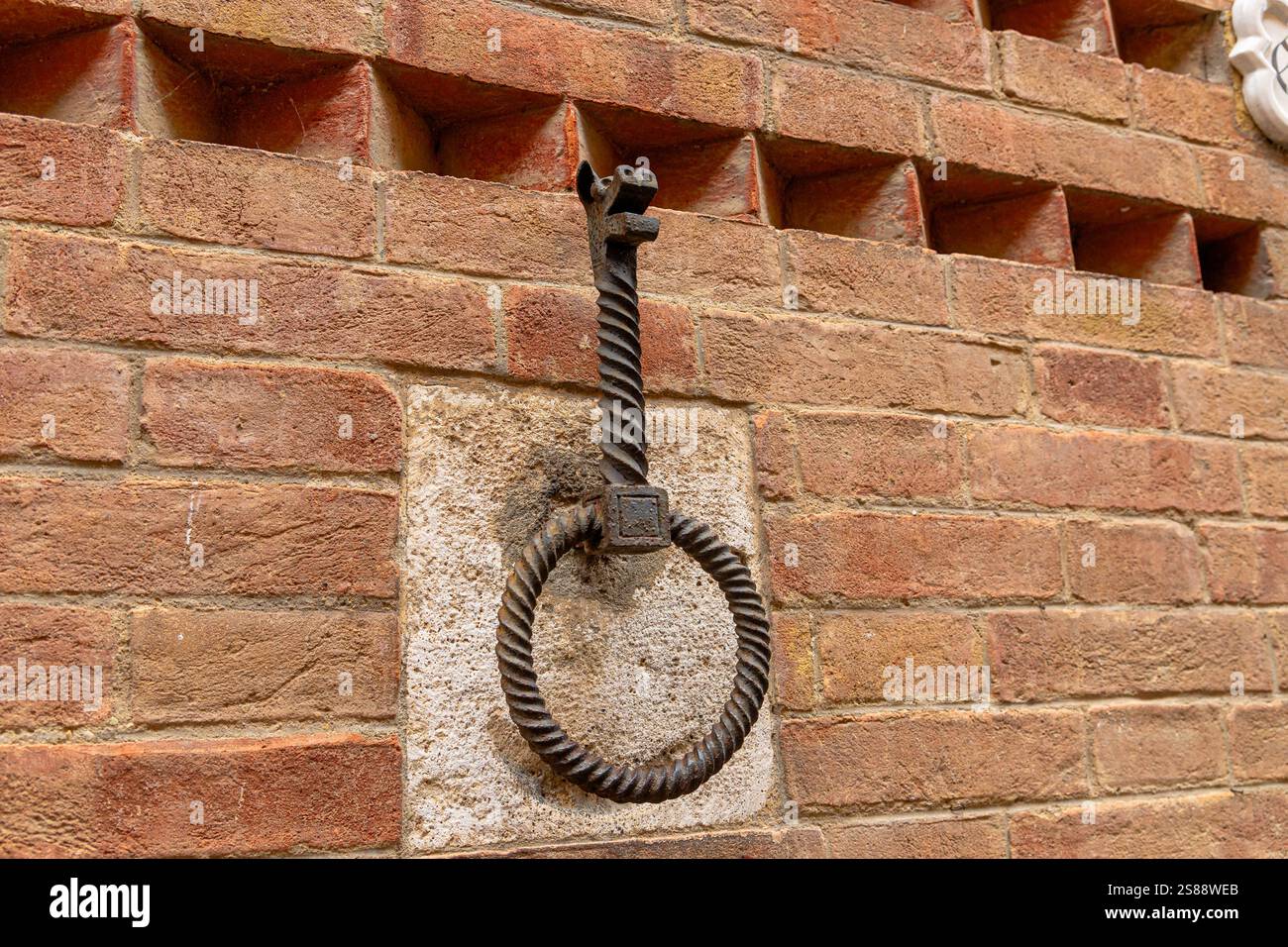 Un anneau de cravate de cheval de fer avec une tête de loup dans la Contrada della Lupa sur un mur dans la ville médiévale de Sienne, Italie Banque D'Images