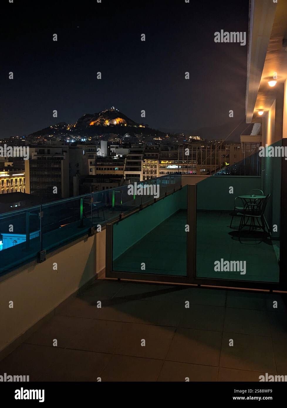 Une vue sereine sur le toit d'Athènes, avec le mont Lycabette illuminé la nuit. Un moment paisible au-dessus de l'énergie vibrante de la ville. - Image de stock capturée avec un smartphone
