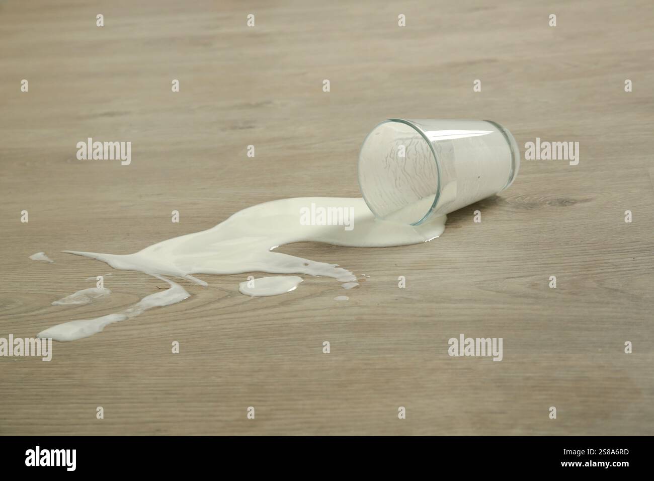 Verre de lait renversé sur le sol Banque D'Images Verre de lait renversé sur le sol Banque D'Images
