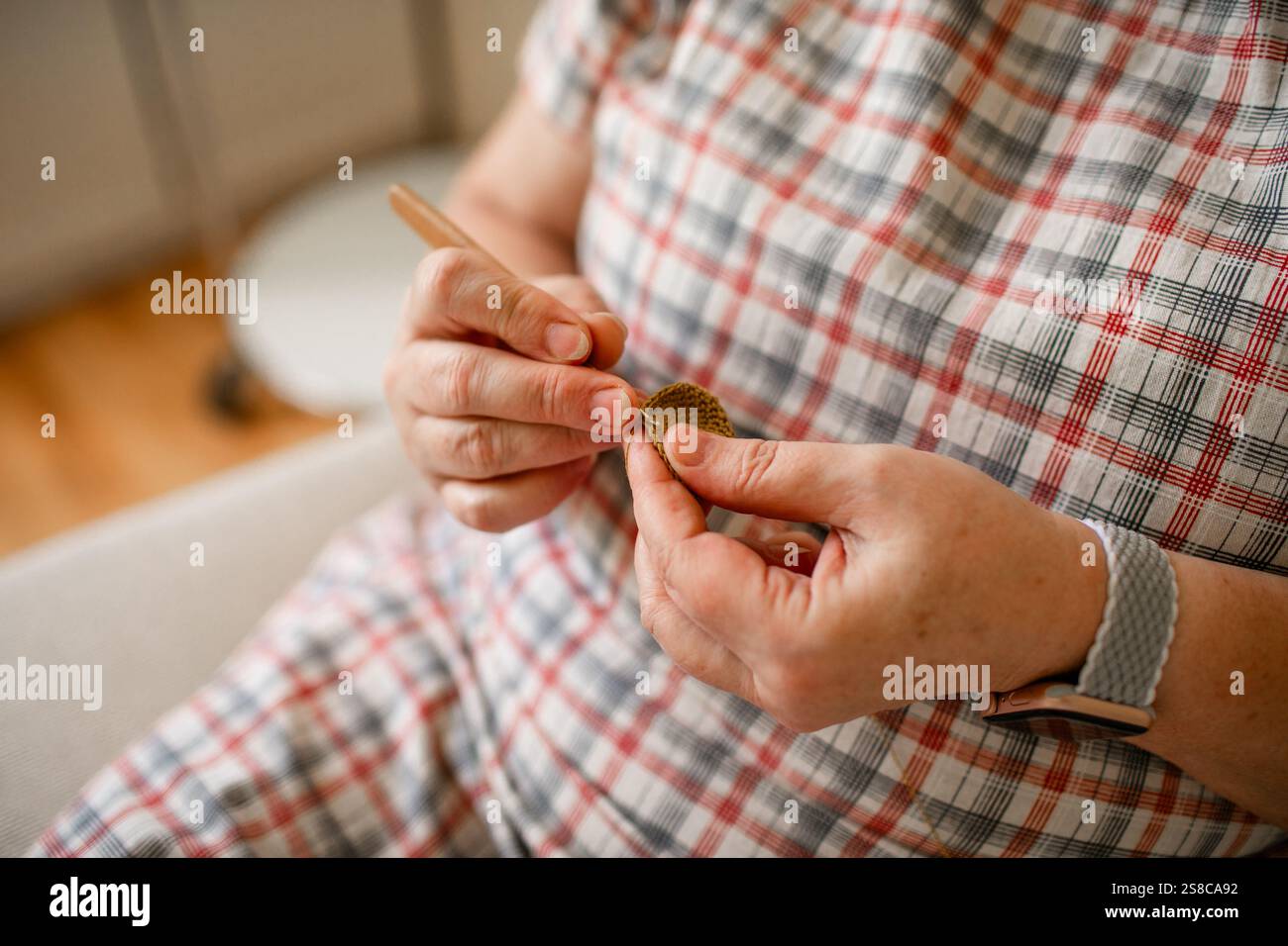 Vue rapprochée des mains d'une femme âgée crochetant. Banque D'Images
