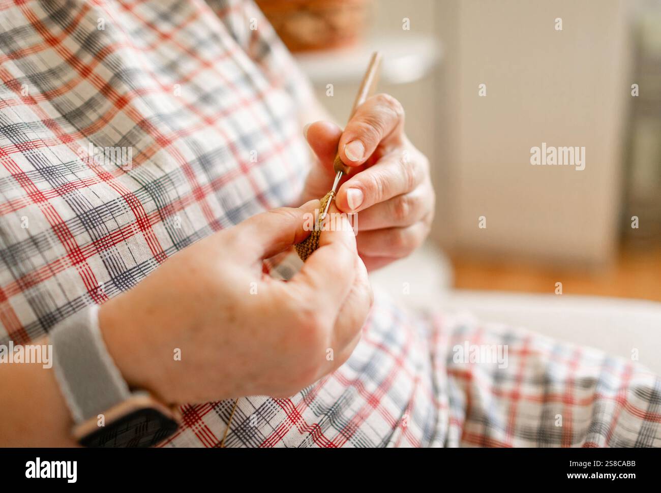 Vue rapprochée des mains d'une femme âgée crochetant. Banque D'Images
