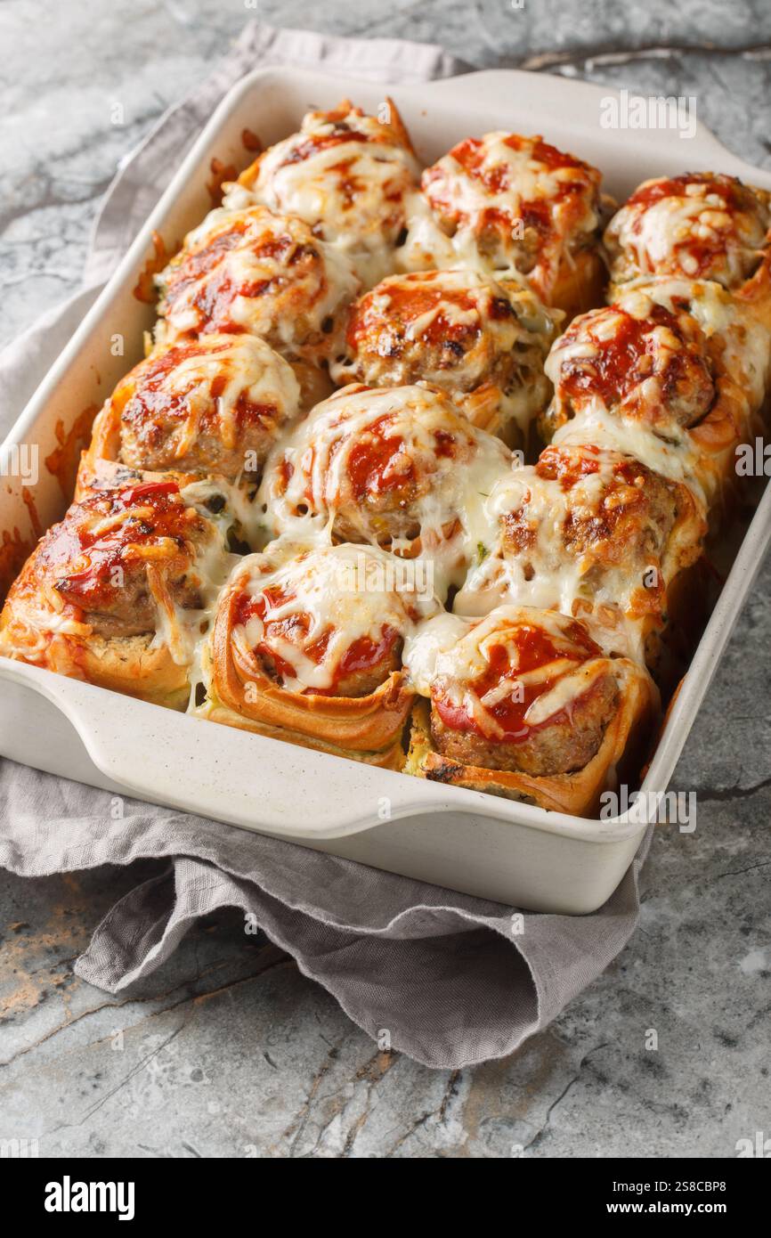 Boulettes de pain à l'ail farcies de boulettes de viande recouvertes de gros plan de fromage sur le plat de cuisson sur la table. Vertical Banque D'Images