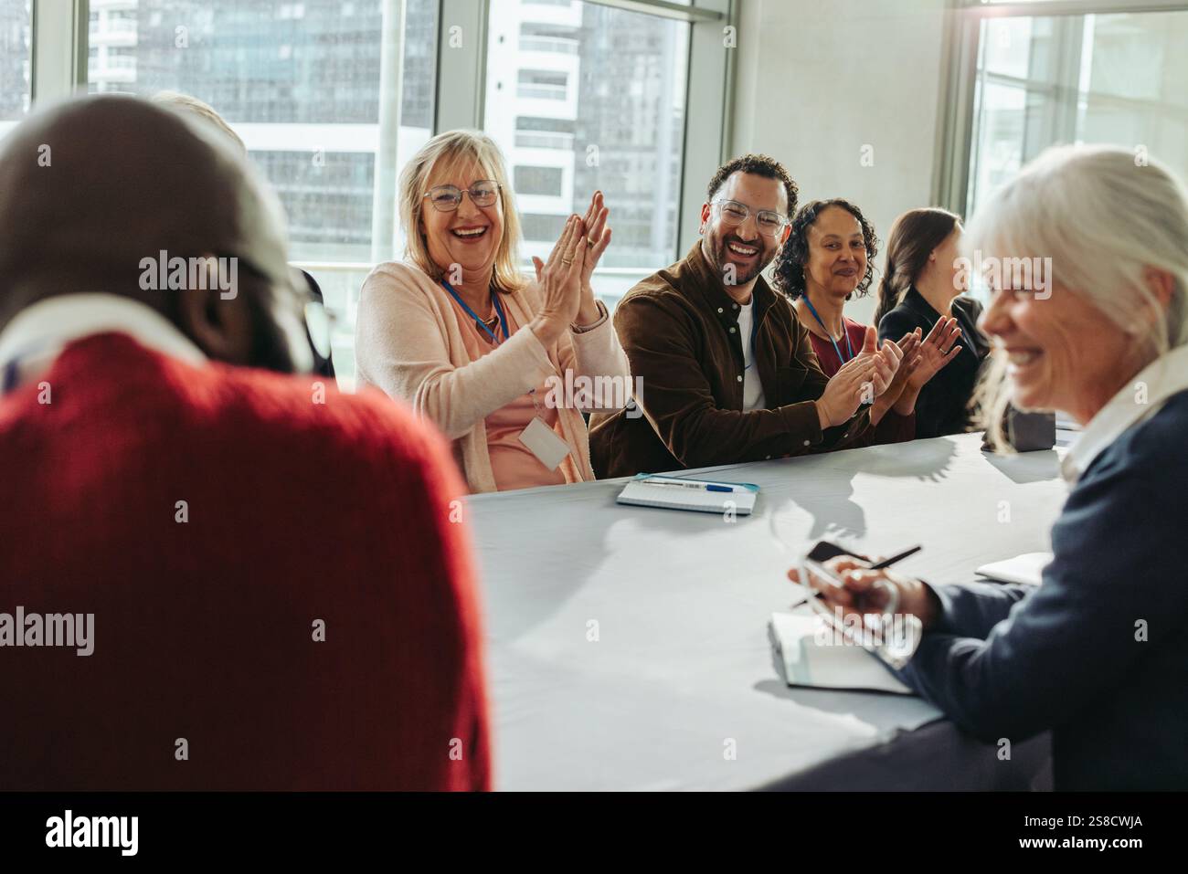 Collègues heureux et prospères lors d'une réunion d'affaires, mettant en valeur le travail d'équipe, la collaboration et l'énergie positive dans un cadre professionnel. Banque D'Images