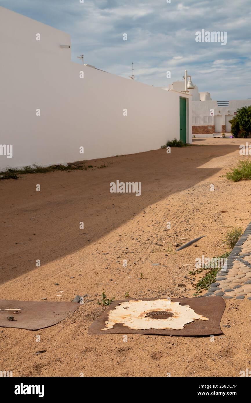 Village avec façade blanche traditionnelle des maisons. Pas de circulation, toutes les rues couvertes de sable. Ciel nuageux en hiver. Caleta del Sebo, la Gracio Banque D'Images