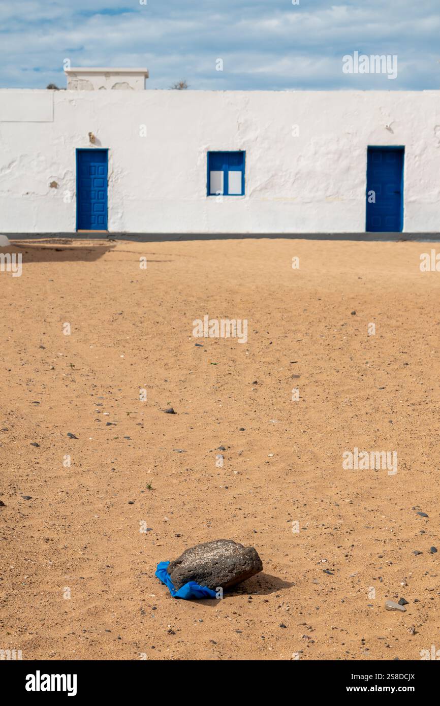 Village avec façade blanche traditionnelle des maisons. Pas de circulation, toutes les rues couvertes de sable. Ciel nuageux en hiver. Caleta del Sebo, la Gracio Banque D'Images