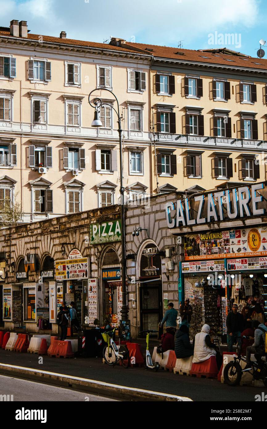 Vie urbaine animée dans une rue animée de Rome, mettant en valeur les façades colorées des entreprises locales et l'agitation quotidienne de ses résidents. Banque D'Images