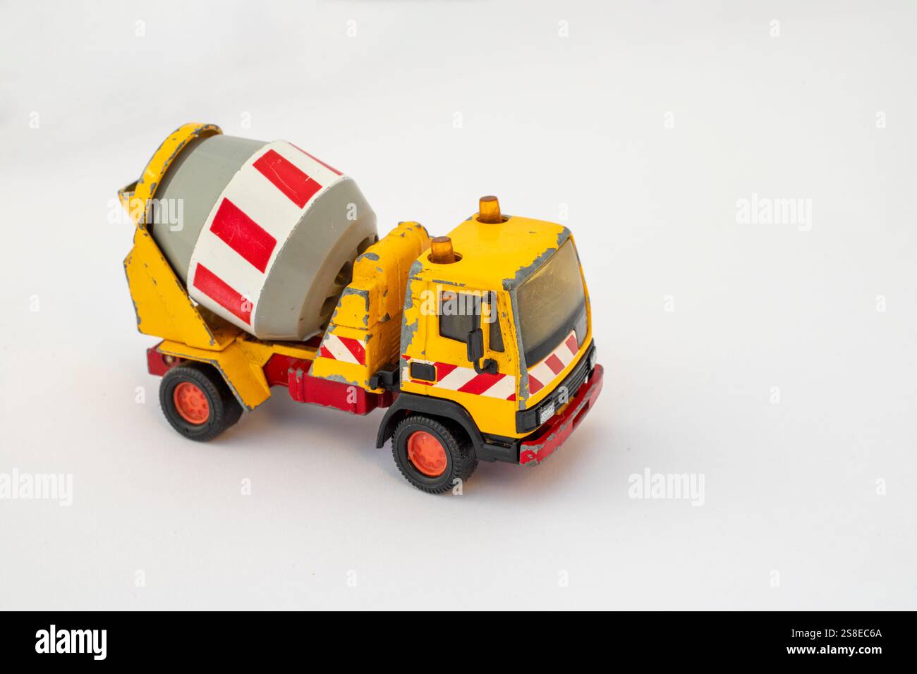 Camion miniature de mélangeur de ciment coulé sous pression sur fond blanc avec espace de copie Banque D'Images