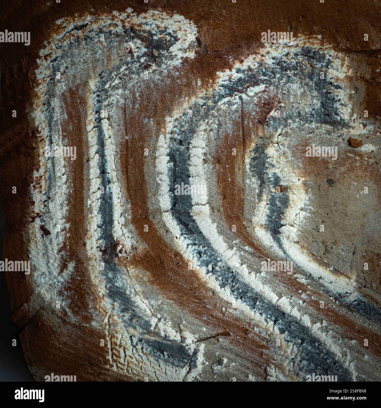 Gros plan d'une pierre naturelle présentant des motifs et des textures en couches distinctives dans des tons terreux de brun et de gris, idéal pour les applications artistiques Banque D'Images