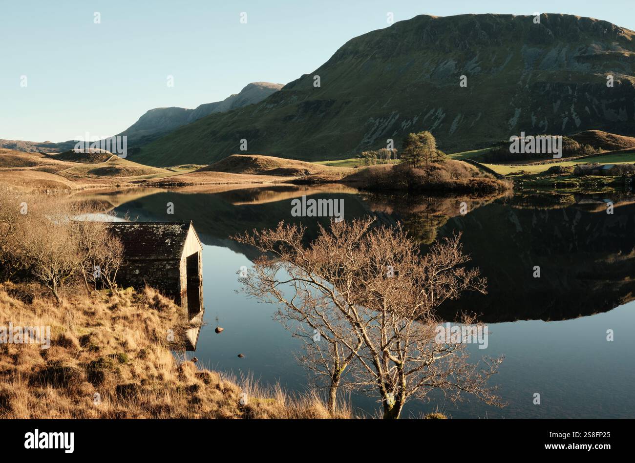 Une maison de bateau se trouve au bord des lacs de Cregennan, ou Llynnau Cregennan, près d'Arthog, Dolgellau dans le nord du pays de Galles avec Cadair Idris en arrière-plan Banque D'Images