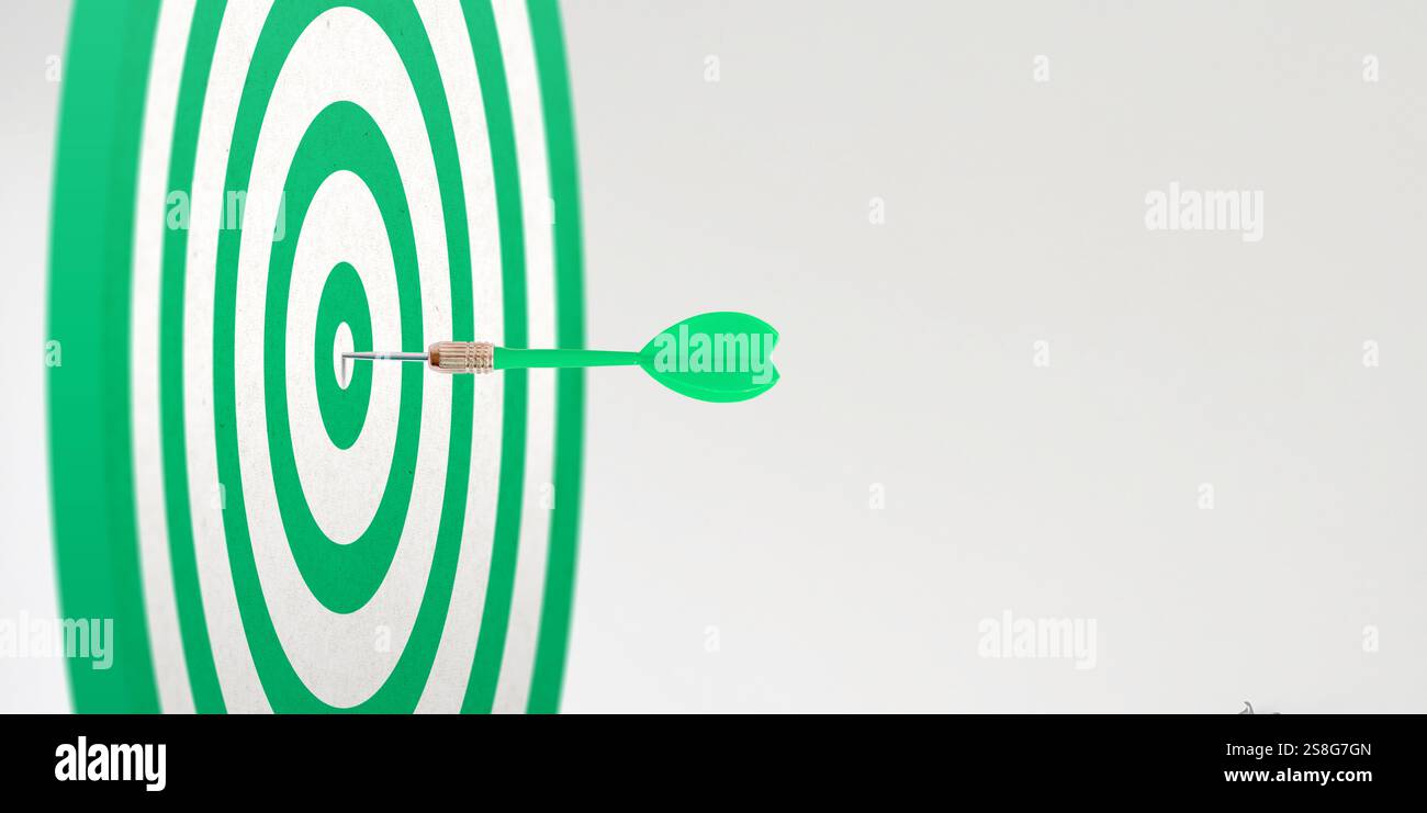 Cible verte avec une fléchette intégrée au centre, avec un espace vide à côté pour le texte promotionnel, symbolisant la précision et l'accent dans le marketing Banque D'Images
