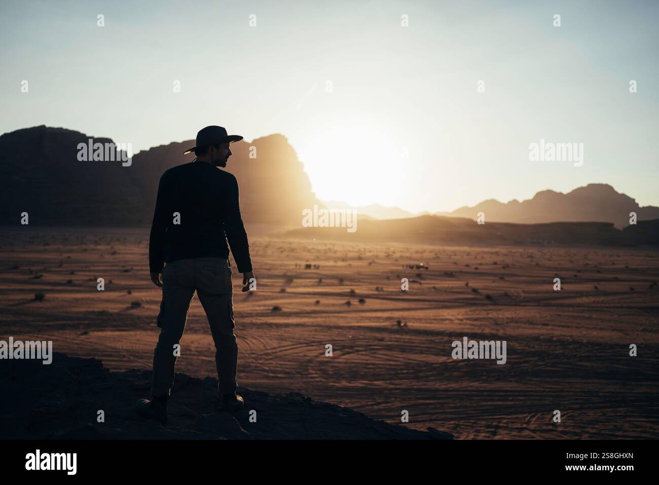 Touriste regardant le coucher du soleil dans le désert de Wadi Rum, Jordanie. Banque D'Images
