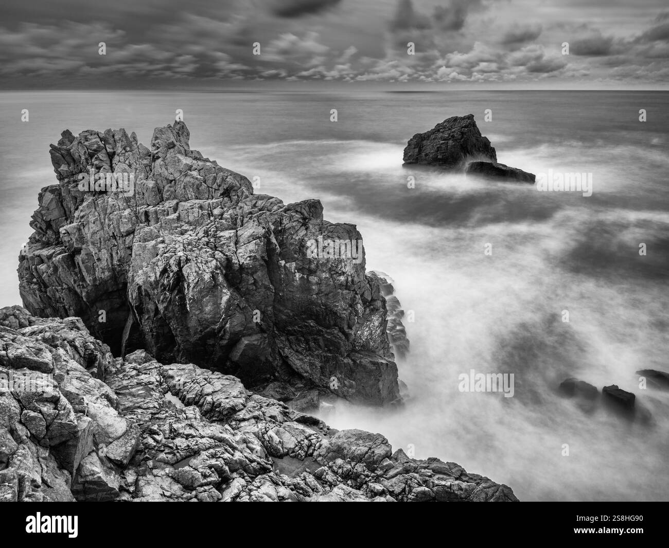 Falaises de mer de granit accidentées, avec une mer floue longue exposition, sur la côte sud de Guernesey, îles Anglo-Normandes. Banque D'Images