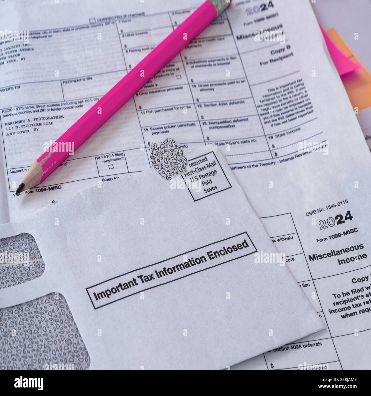 Préparation des déclarations avril 2025 concept : formulaire d'impôt sur le revenu DES ÉTATS-UNIS 1099 et enveloppe IRS et documents sur un bureau en désordre ; crayon rose pour les calculs. Banque D'Images
