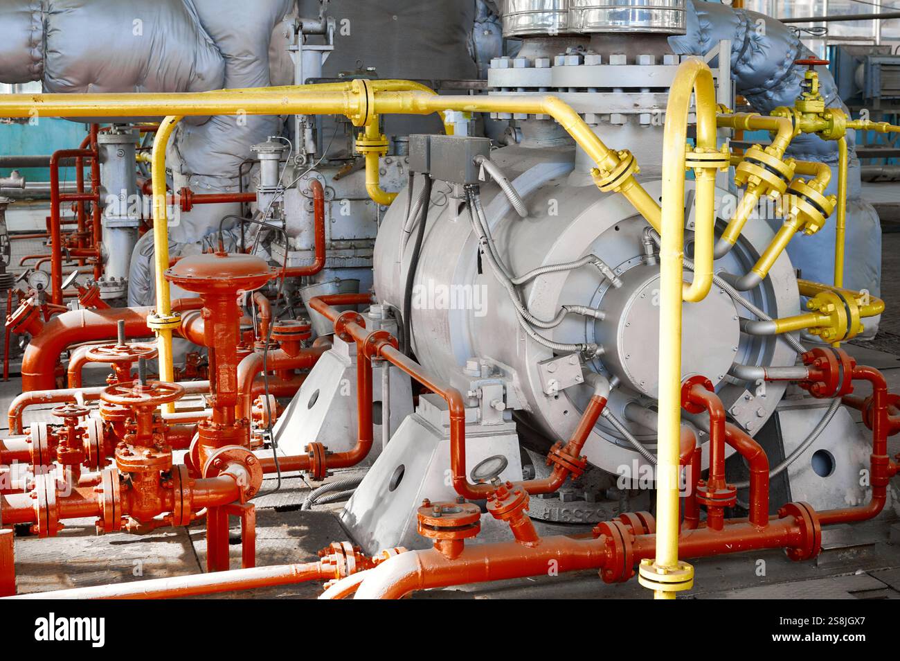 La pompe industrielle puissante fonctionne efficacement dans le réseau de tuyauterie complexe d'une usine chimique pendant les opérations régulières Banque D'Images