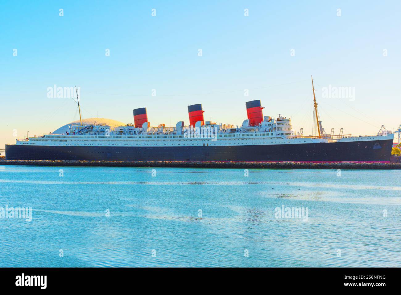 Long Beach, Californie - 15 janvier 2025 : navire historique Queen Mary amarré dans le port de long Beach, avec des cheminées rouges et noires emblématiques avec calme Banque D'Images