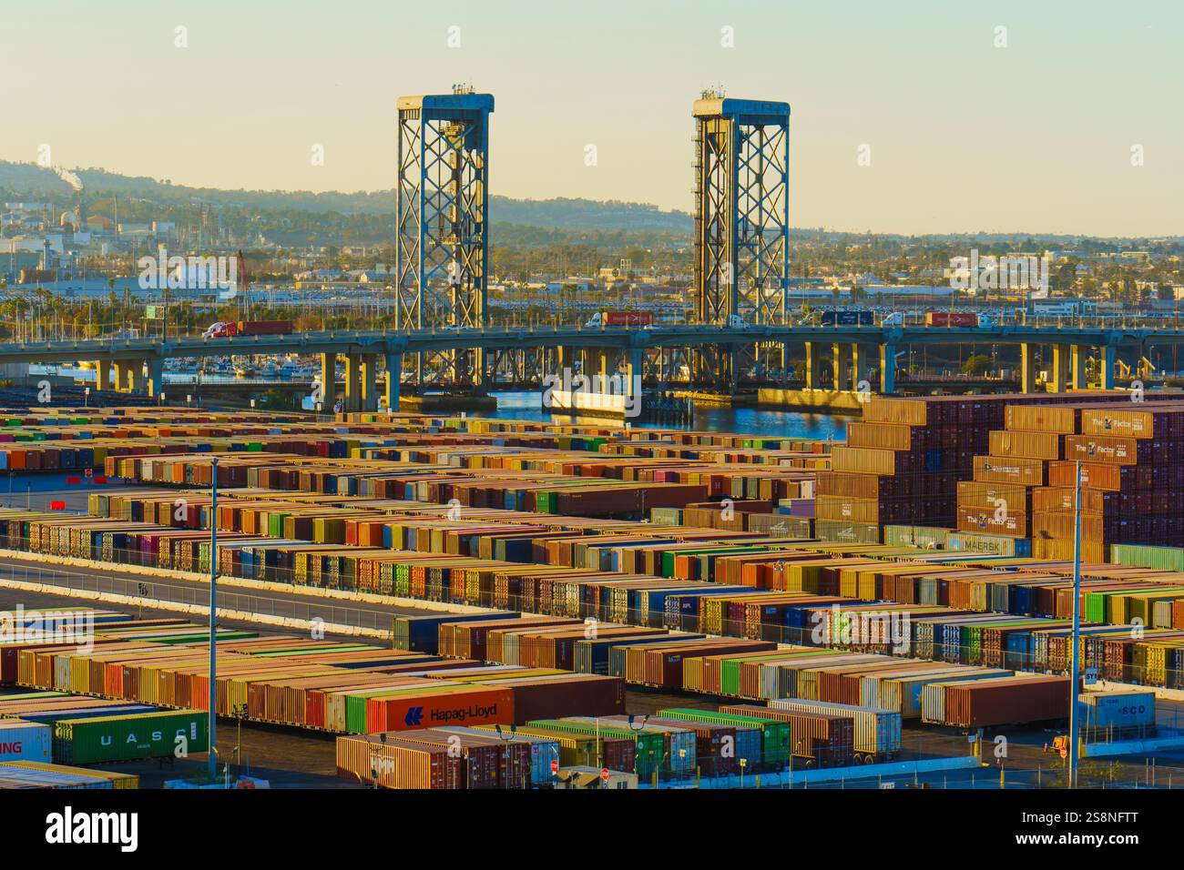 Long Beach, Californie - 15 janvier 2025 : vue d'ensemble des conteneurs maritimes empilés avec les ponts élévateurs en arrière-plan, mettant en vedette l'opérat occupé Banque D'Images