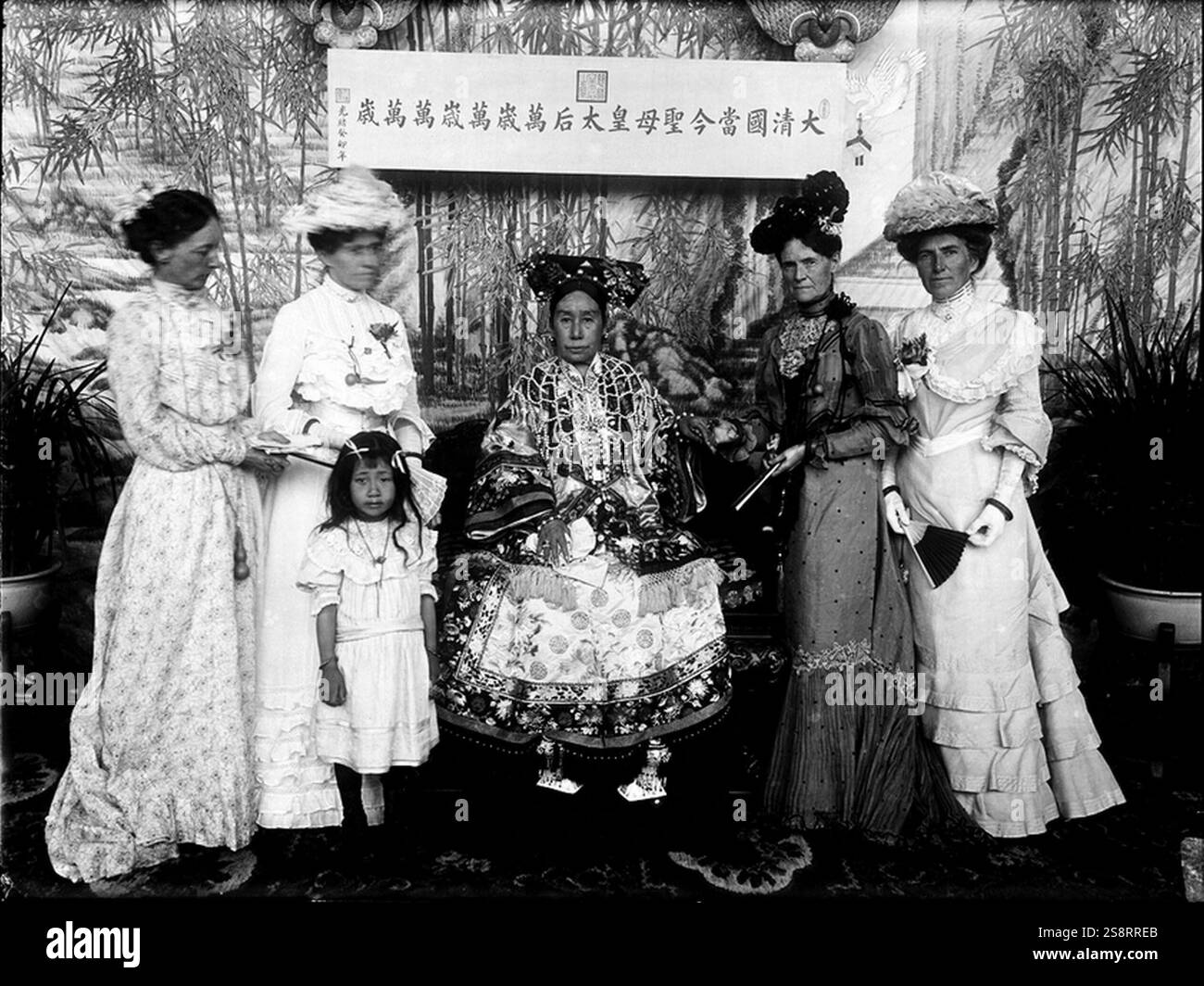 L'impératrice douairière Cixi, Tzu-hsi (1835-1908) était une impératrice chinoise qui a officieusement mais effectivement contrôlé la dynastie mandchou Qing en Chine pendant 47 ans, de 1861 à sa mort en 1908. L'impératrice douairière, représentant la Déesse de la Miséricorde (Guanyin), soutenue par Li lien-Ying (à droite) et deux dames de la cour Banque D'Images