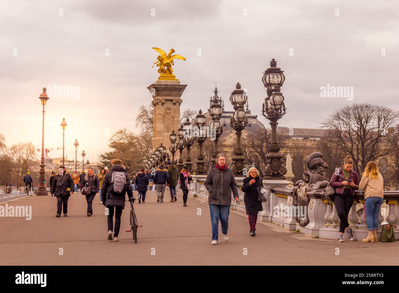 Paris, France - 5 mars 2023 : des gens marchent sur le pont Alexandre III. L'attraction traditionnelle est connue comme le pont le plus orné et le plus extravagant Banque D'Images