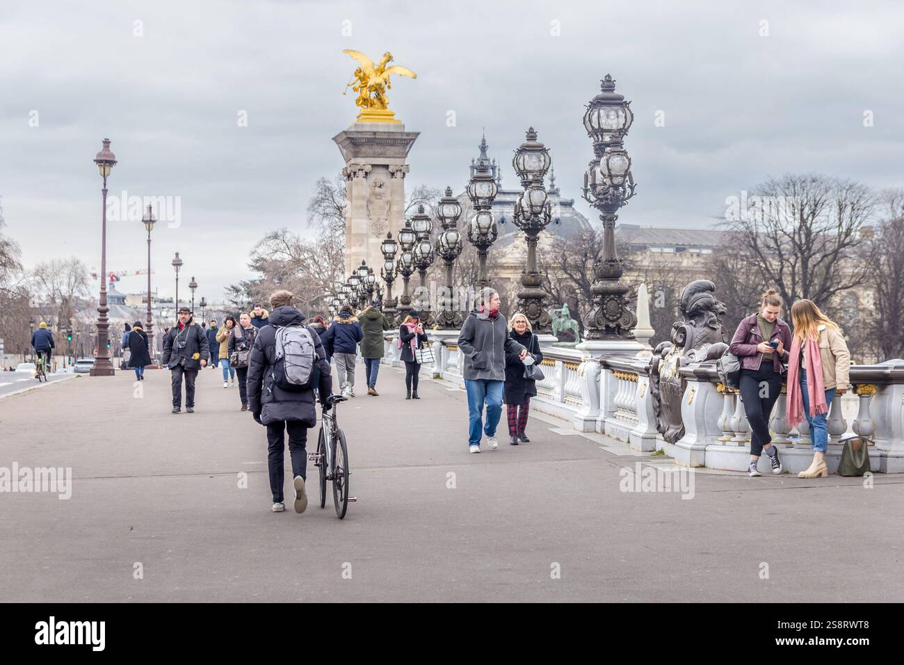 Paris, France - 5 mars 2023 : des gens marchent sur le pont Alexandre III. L'attraction traditionnelle est connue comme le pont le plus orné et le plus extravagant Banque D'Images