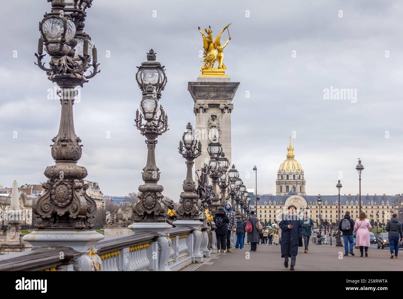 Paris, France - 5 mars 2023 : des gens marchent sur le pont Alexandre III. L'attraction traditionnelle est connue comme le pont le plus orné et le plus extravagant Banque D'Images