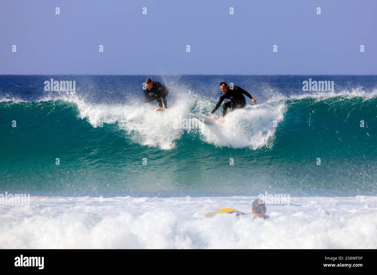Deux surfeurs sur la même vague, Piedra Playa, El Cotillo, Fuerteventura, îles Canaries, Espagne. Prise en novembre 2024 Banque D'Images