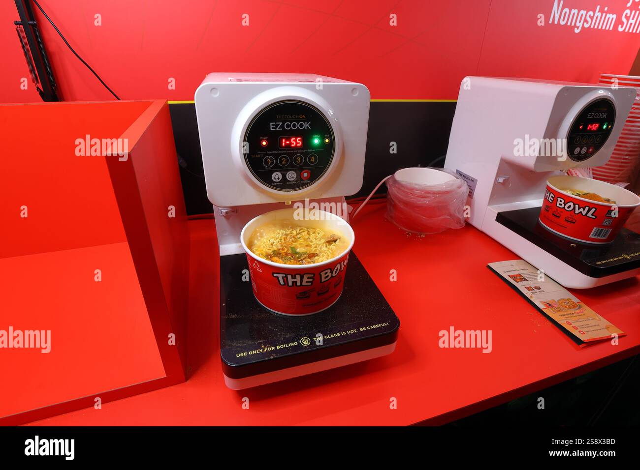 Cuiseur ramen instantané Touch on EZ Cook en libre-service avec un paquet de Nongshim Ramyun dans un bol en papier chauffé par induction cuit par induction Banque D'Images