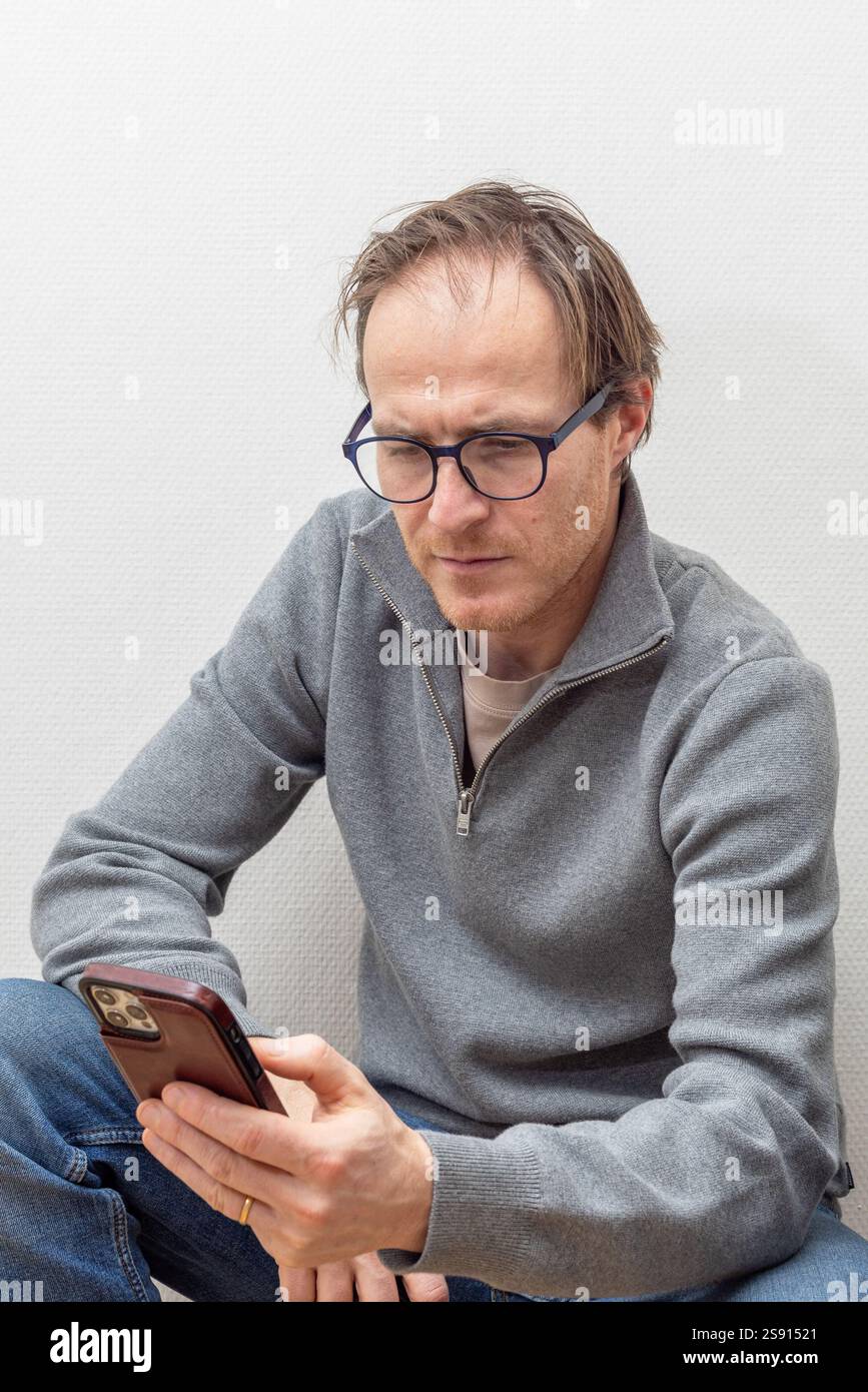 Homme vérifiant smartphone avec mise au point Banque D'Images