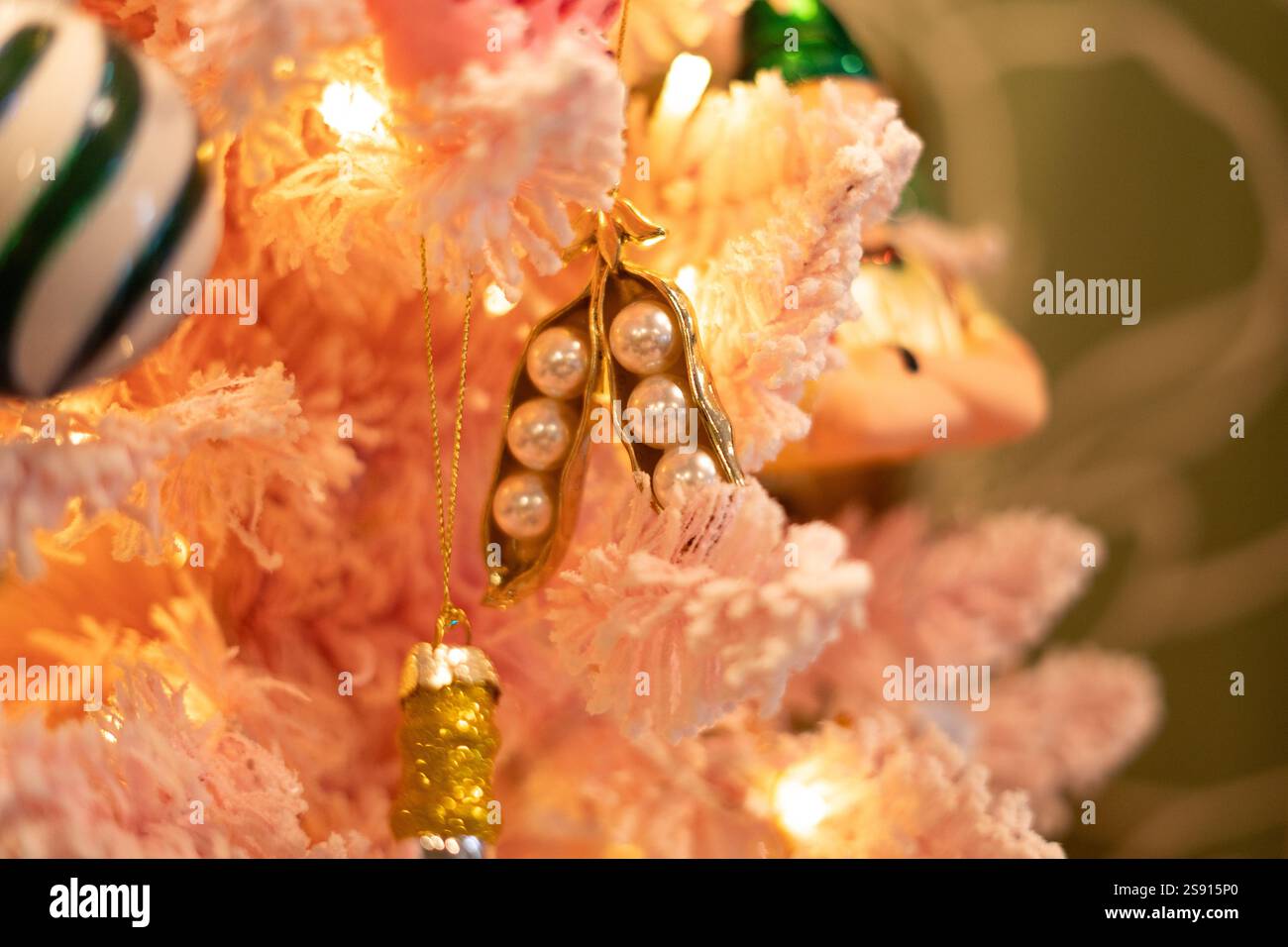 ornements délicats de perles et d'or sur arbre de noël rose clair Banque D'Images