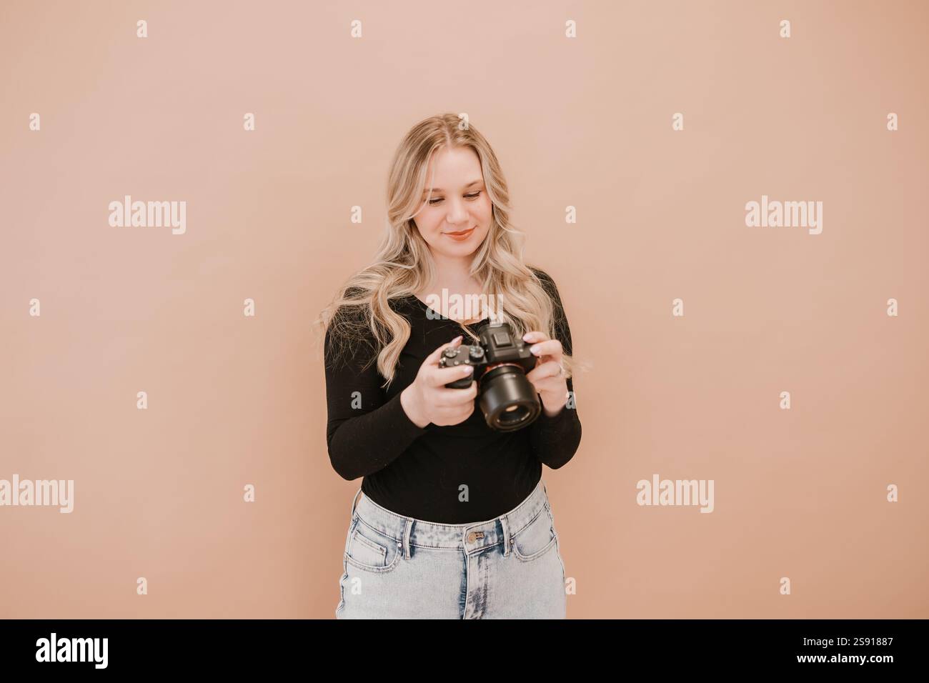 Photographe souriant regardant un appareil photo dans un studio Banque D'Images