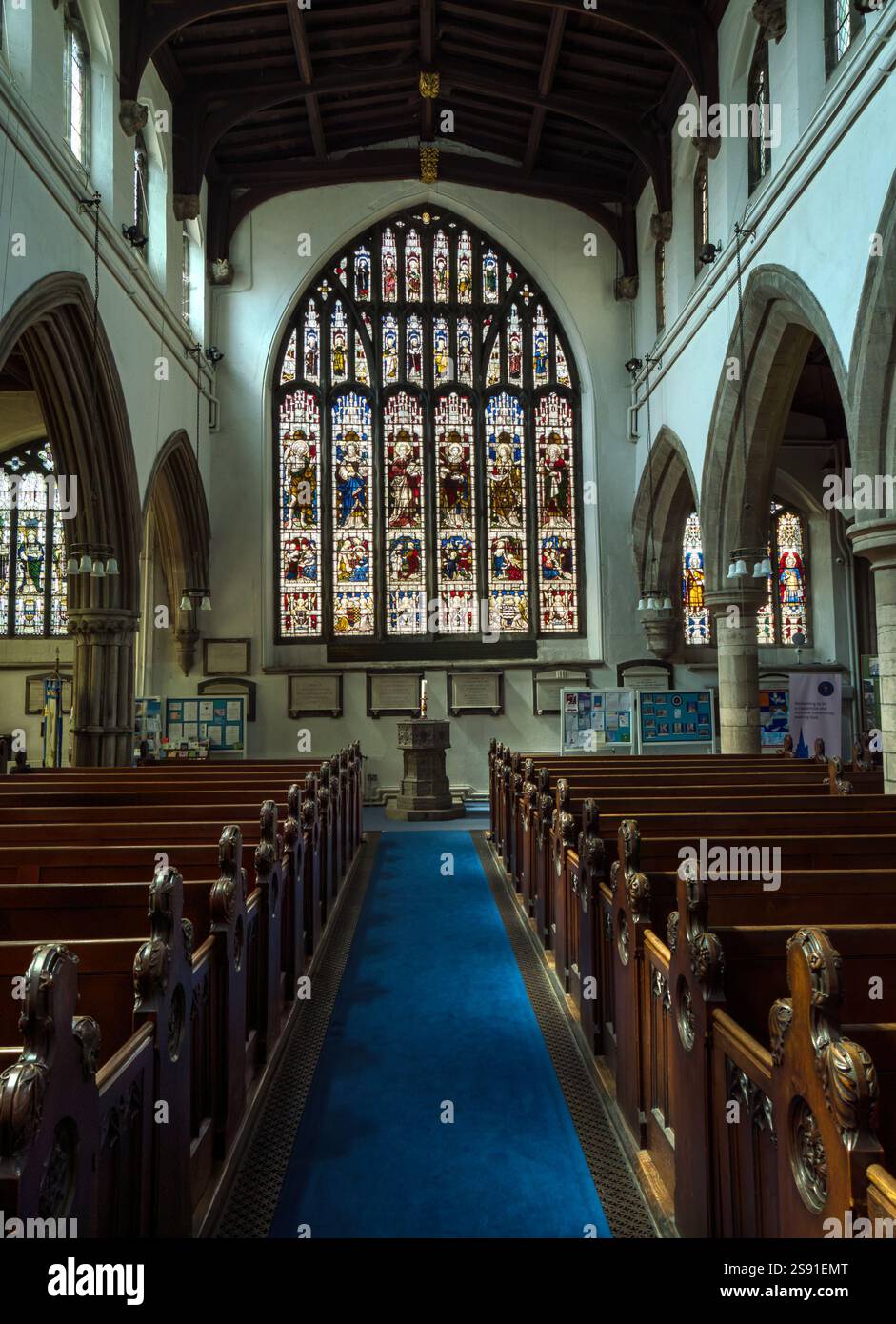 Bancs de chêne et vitraux et allée à l'intérieur de l'église All Saints, Lincolnshire, Stamford, Royaume-Uni Banque D'Images