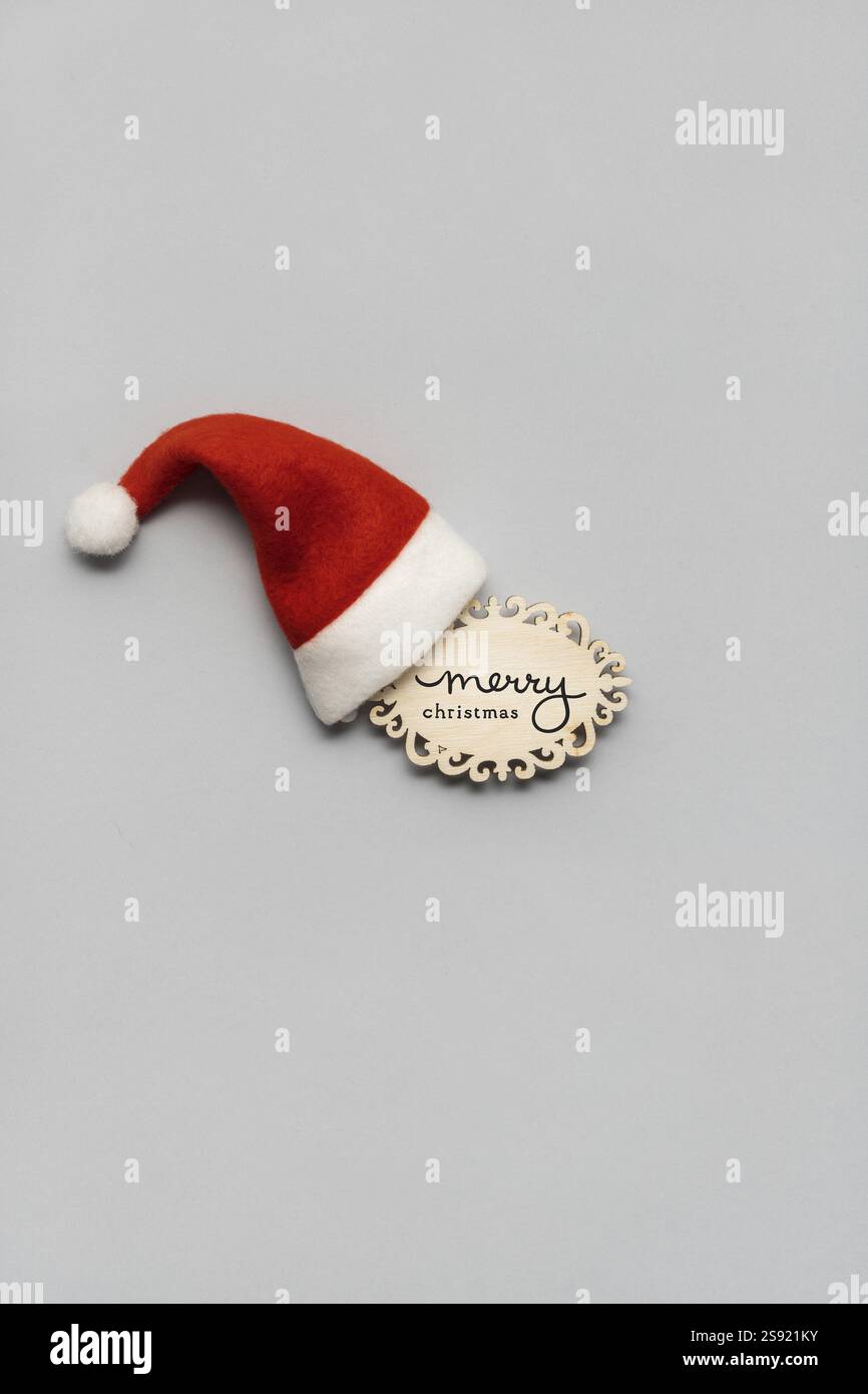 Photo de concept créatif de chapeau de Père Noël et signe fond gris Banque D'Images