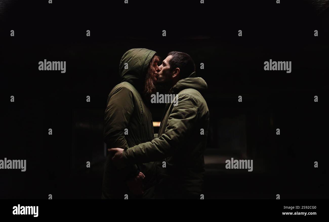 Un couple s'embrasse dans l'obscurité. Banque D'Images