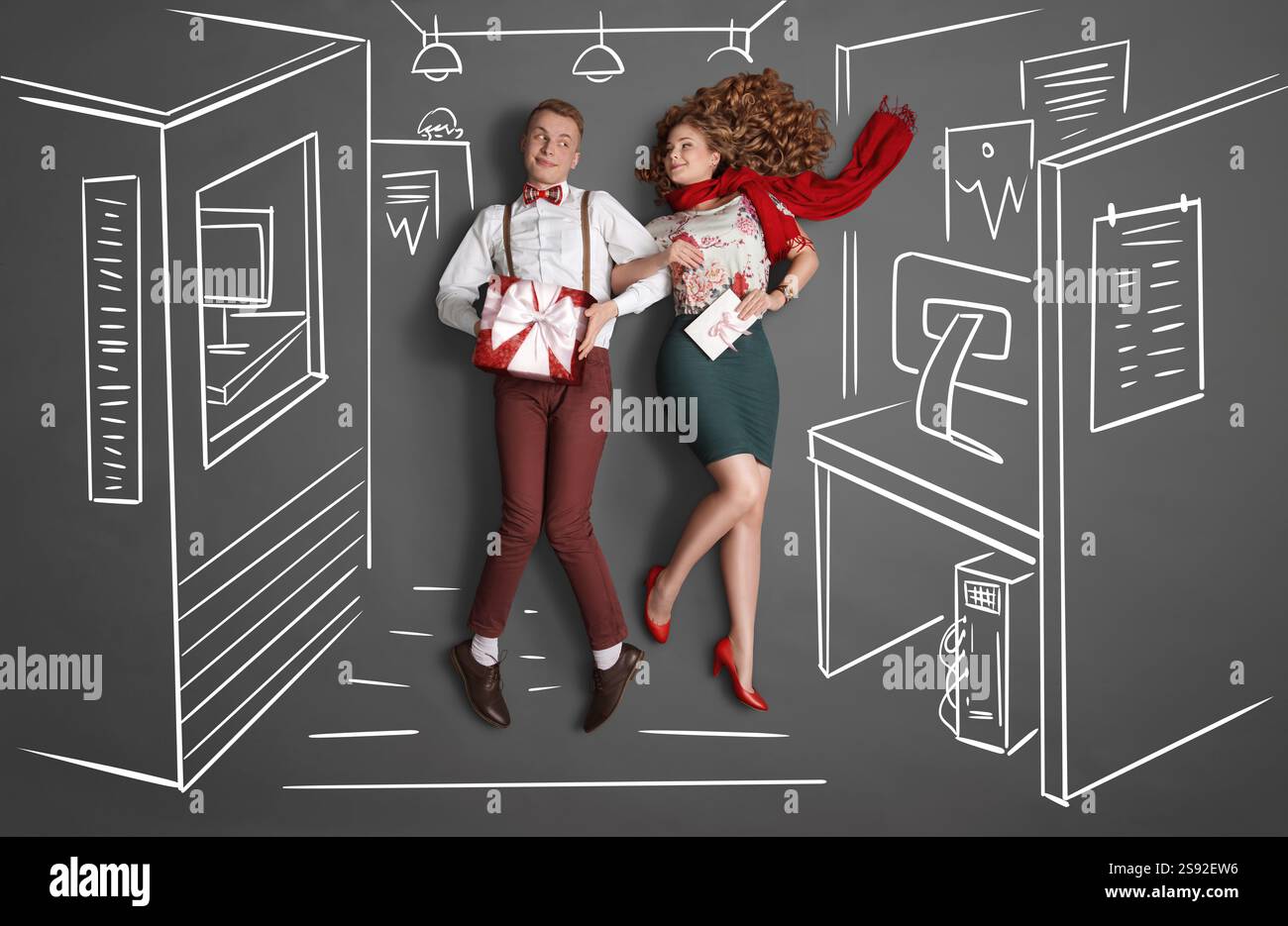 Happy Valentines Love Story concept d'une romance de bureau. Jeune couple au travail souriant l'un à l'autre et échangeant des cadeaux contre des dessins à la craie offic Banque D'Images