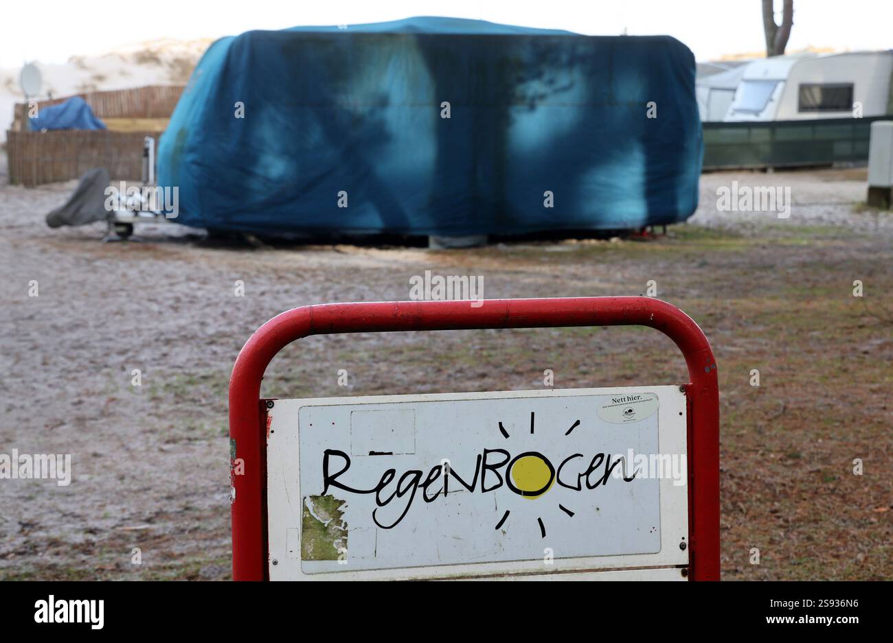 PRODUCTION - 24 janvier 2025, Mecklembourg-Poméranie occidentale, Prerow : un panneau indiquant «Arc-en-ciel» sur le camping dans les dunes de la mer Baltique, avec une caravane couverte derrière elle. L’ancien opérateur, Regenbogen AG, doit quitter certaines parties du camping à la suite d’une décision de justice. Le tribunal de district de Stralsund est toujours saisi d'une décision dans le différend juridique concernant une autre région. Photo : Bernd Wüstneck/dpa Banque D'Images