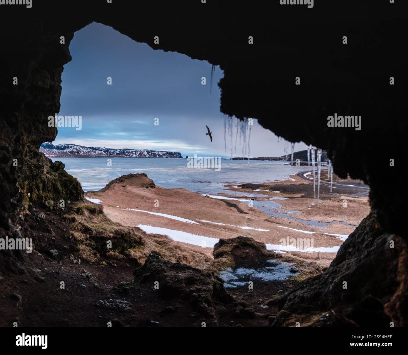 Vue depuis la grotte de Loftsalahellir avec les piles de mer de Reynisdrangar en arrière-plan, sud de l'Islande Banque D'Images