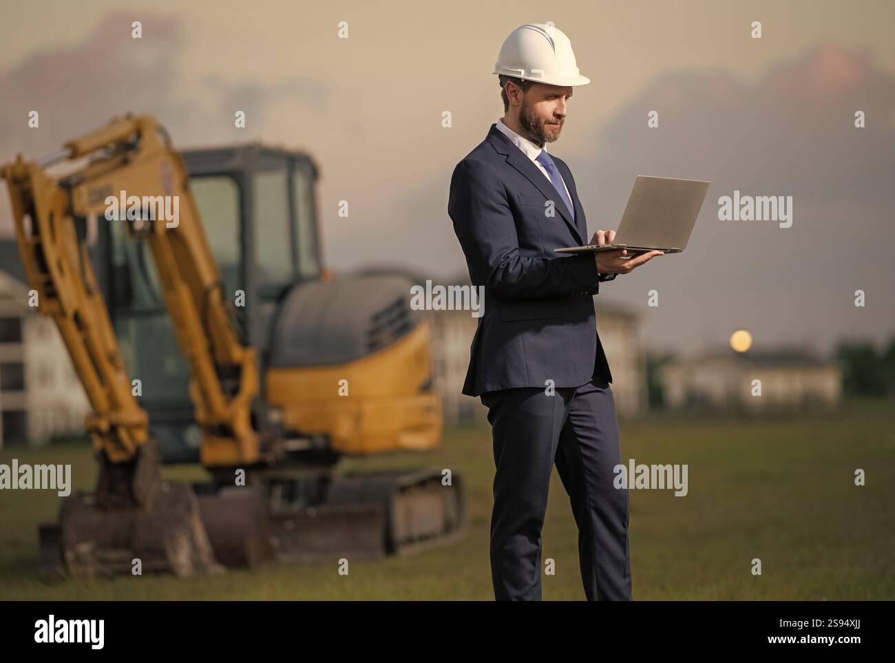 Architecte sur un chantier de construction. Architecte homme en casque et costume à la construction moderne de maison. Architecte avec gilet et costume de sécurité. Confid Banque D'Images