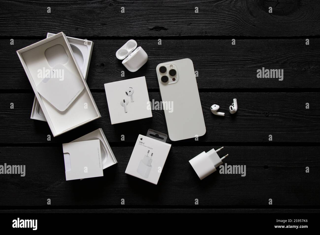 Ukraine Dnipro janvier 24, 2025 - Apple iPhone 15 Pro Max blanc et Apple Air Pods 4 écouteurs et chargeur sur la table avec des boîtes Banque D'Images