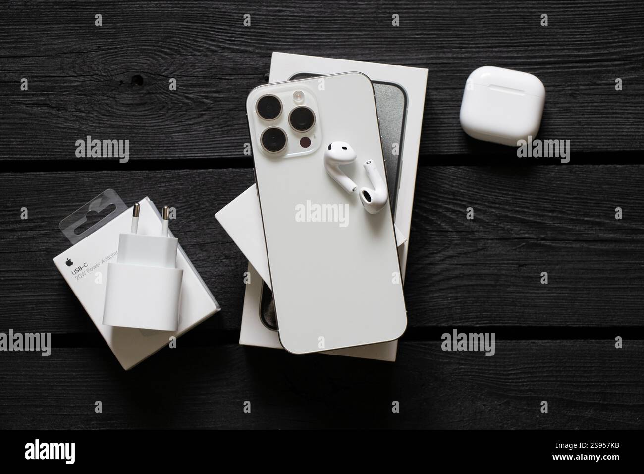 Ukraine Dnipro janvier 24, 2025 - Apple iPhone 15 Pro Max blanc et Apple Air Pods 4 écouteurs et chargeur sur la table avec des boîtes Banque D'Images
