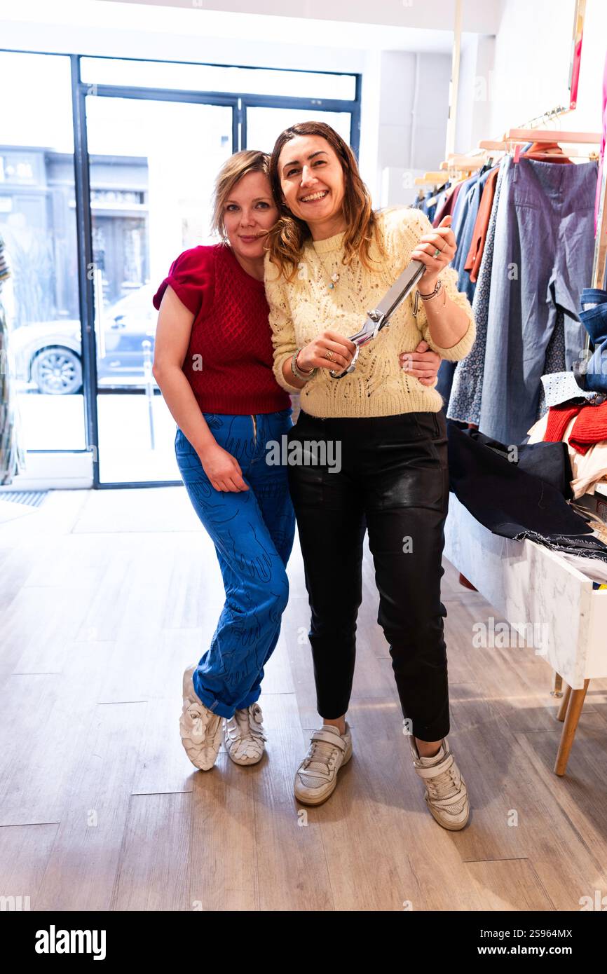 Créatrice de mode de la marque Koshka Paris tient des ciseaux dans sa boutique tout en se tenant debout à côté d'un styliste personnel, Paris, France, Europe Banque D'Images