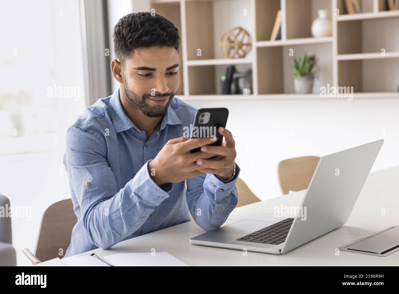 Jeune homme tenant smartphone, lire le message, télécharger la nouvelle application Banque D'Images