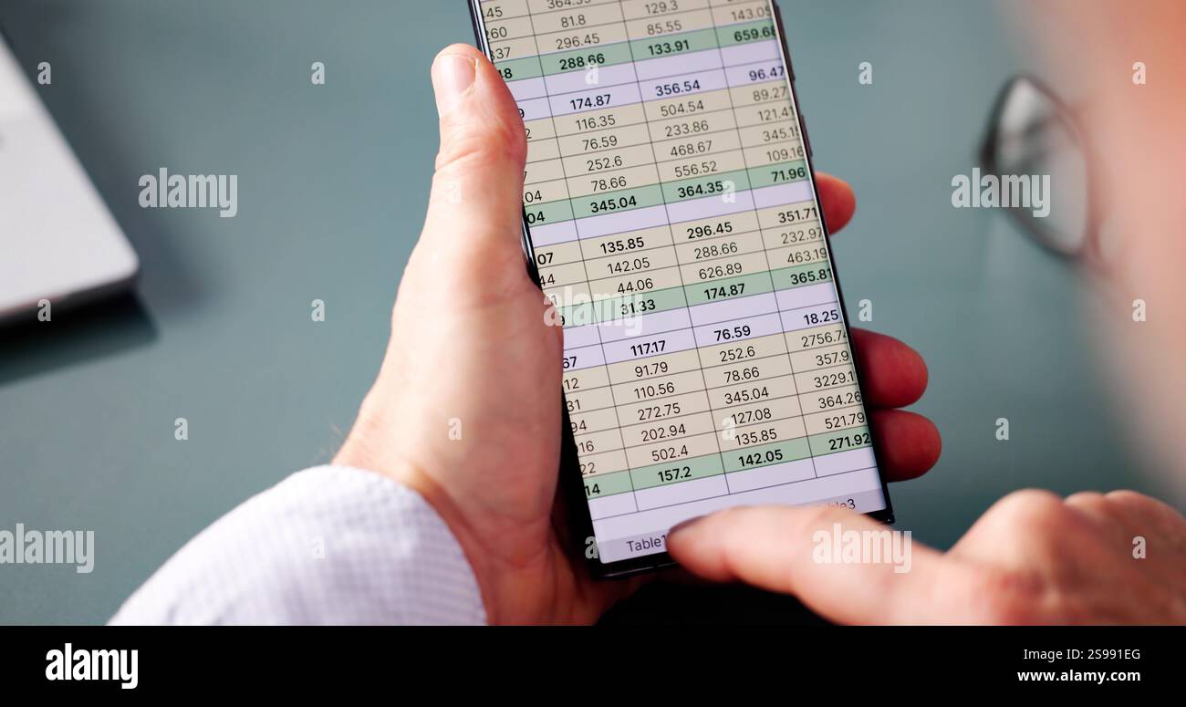 Analyste de données de feuille de calcul utilisant un logiciel informatique sur téléphone Banque D'Images