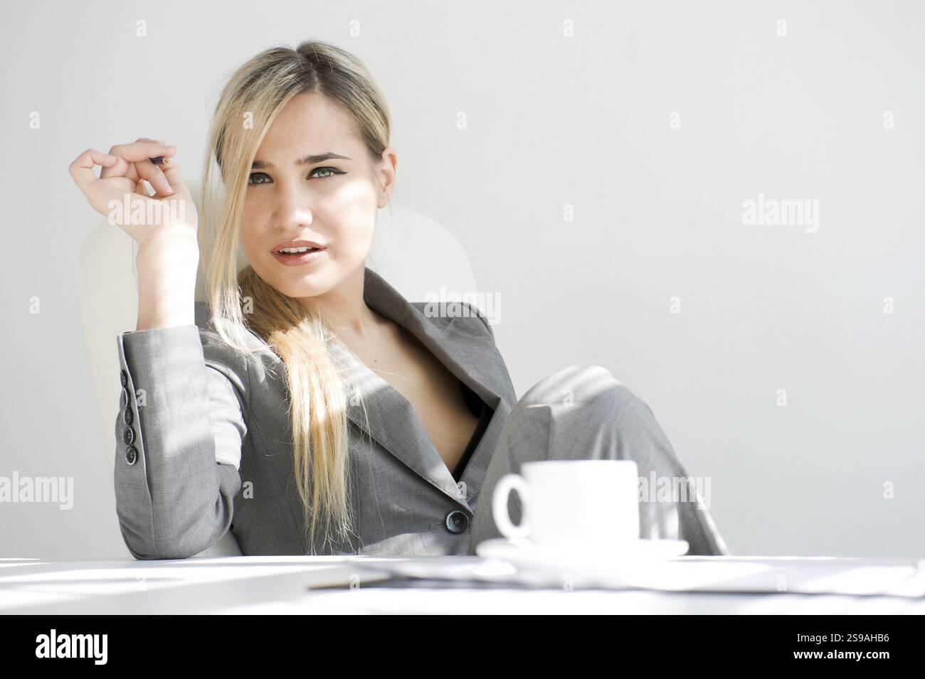 Jeune belle femme d'affaires assise dans le bureau. Pause avec une tasse de café, ST. Pétersbourg, Russie, Europe Banque D'Images