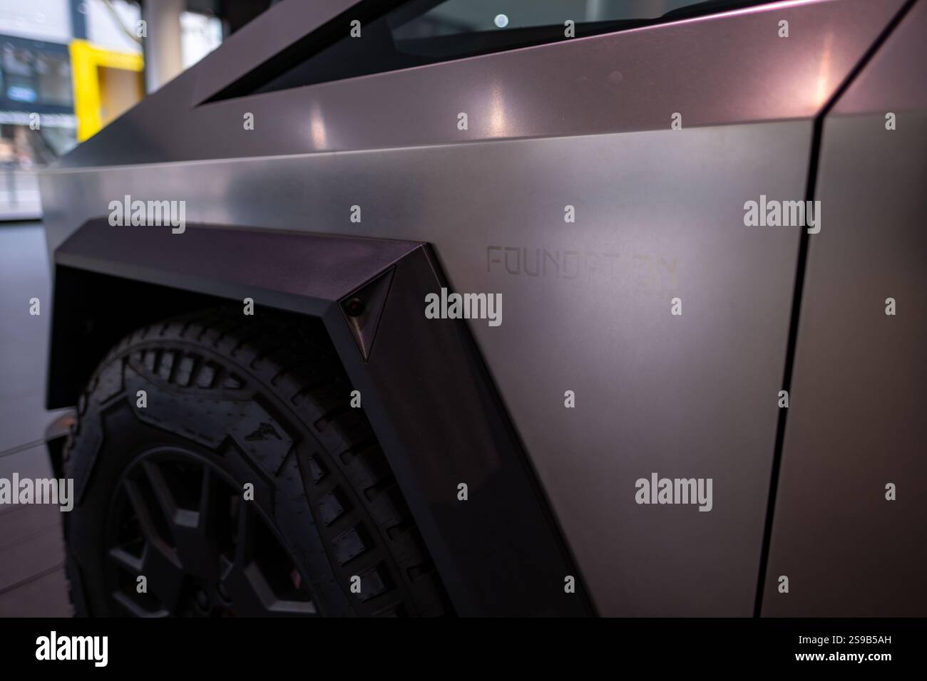Futuriste argent élégant Tesla Cybertruck fondation, ev redéfinissant les camionnettes affichées dans la salle d'exposition moderne, puissance électrique Elon Musk société, uniqu Banque D'Images