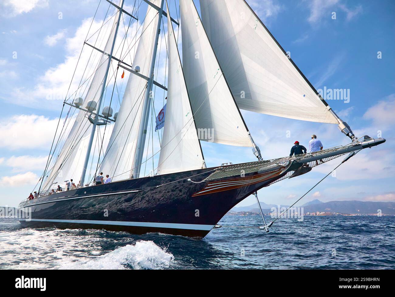 Le voilier de luxe Meteor Gliding Across Ocean avec White Sails in Blue Sky Banque D'Images
